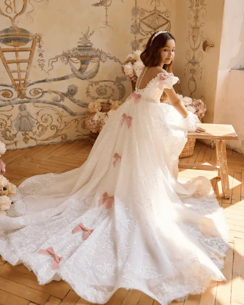 Communiejurk voor meisjes met lange sleep, ivoor kant en roze strikken uit de So Cute winkel