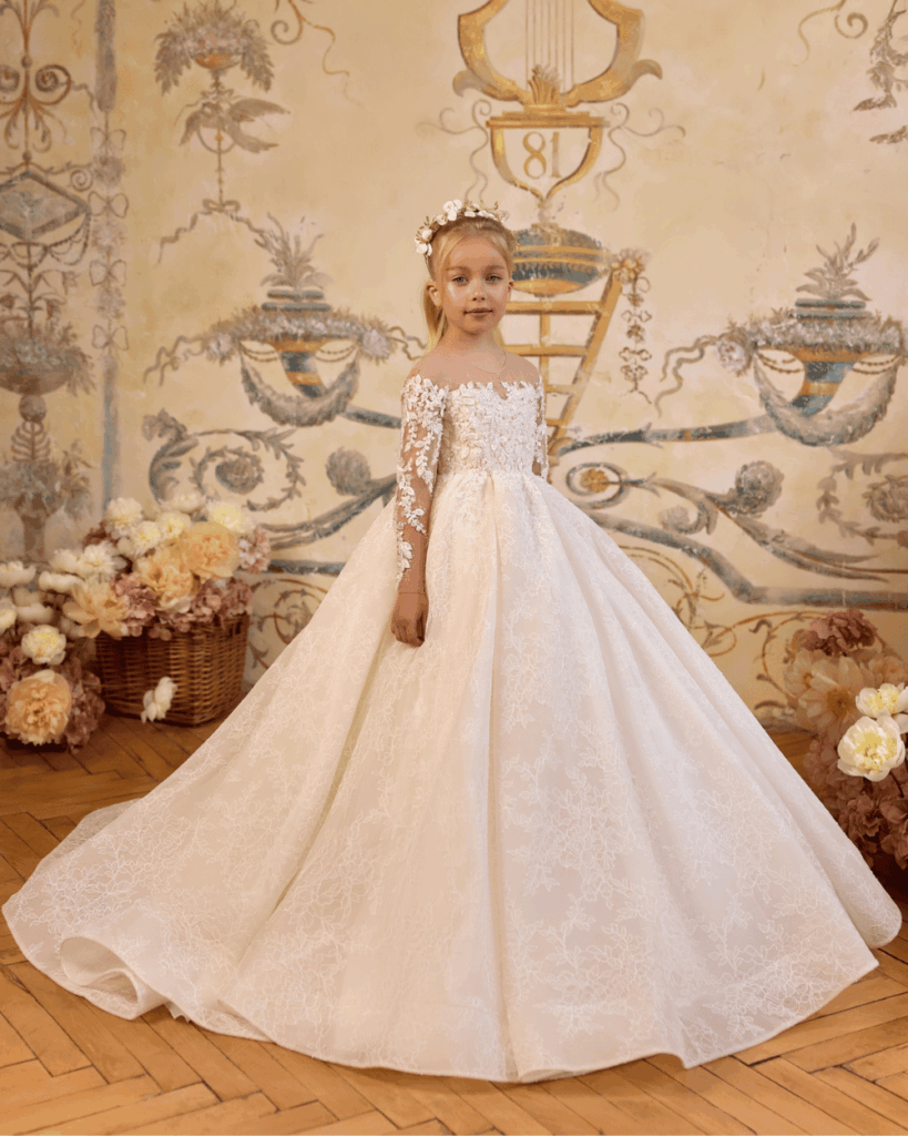 Elegante ivoorkleurige communiejurk met lange kanten mouwen en wijde rok uit de So Cute winkel