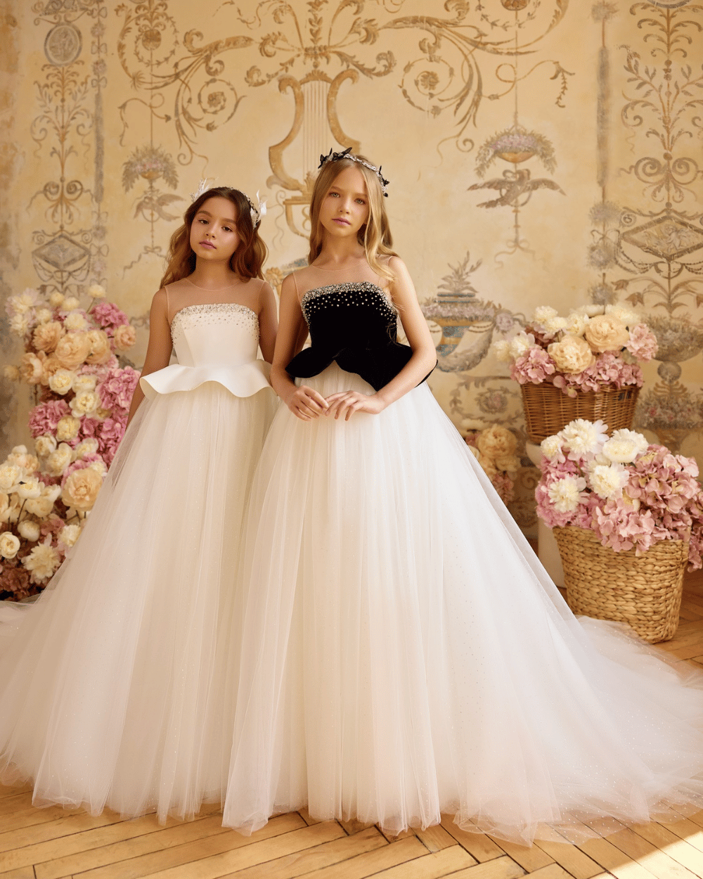 Elegante communiejurk met pareldetails en moderne peplum, gedragen in een romantische bloemenstudio.